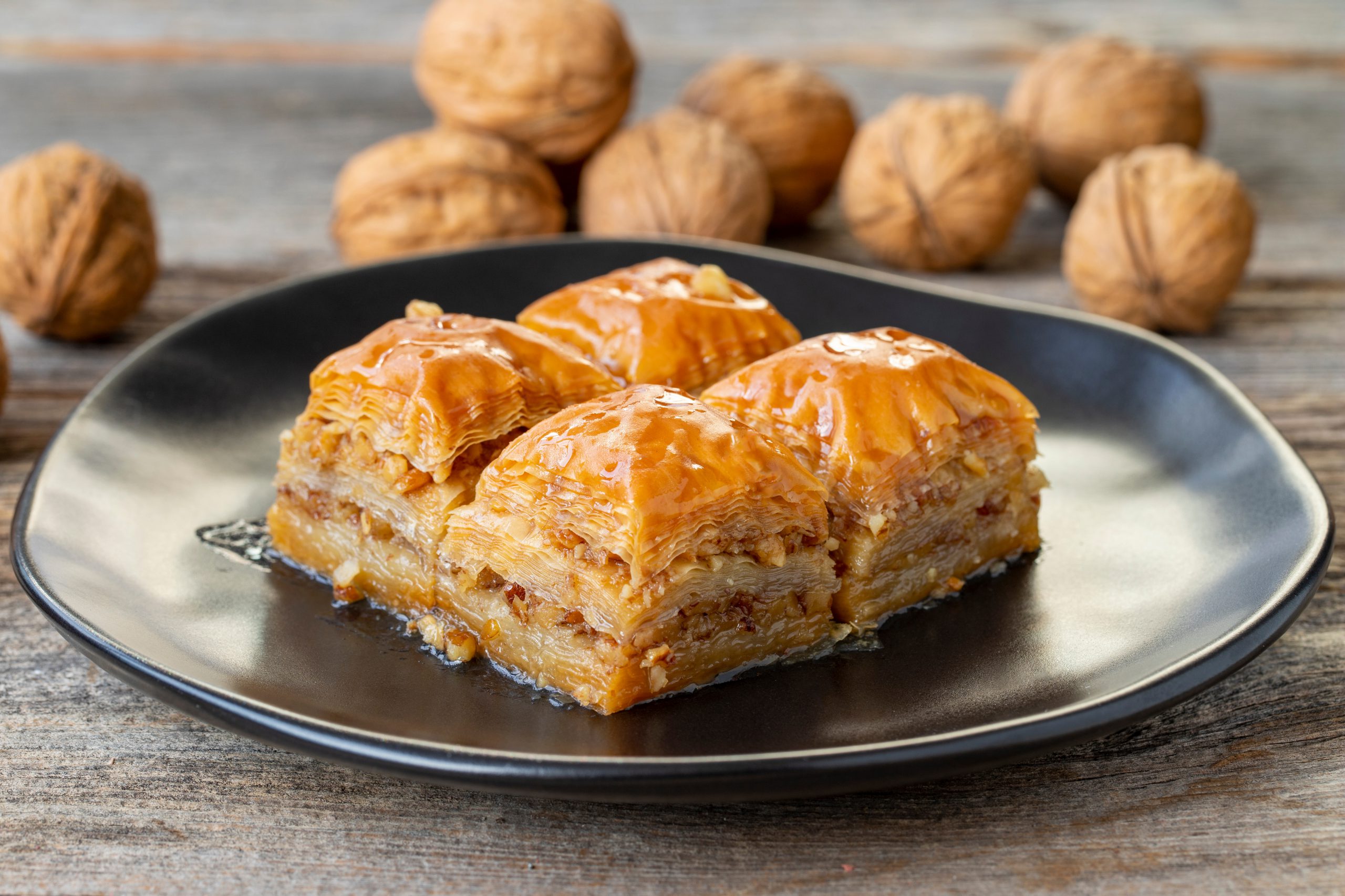 Walnut Baklava on wooden background. Turkish style walnut baklava presentation and service. Horizontal view. close up